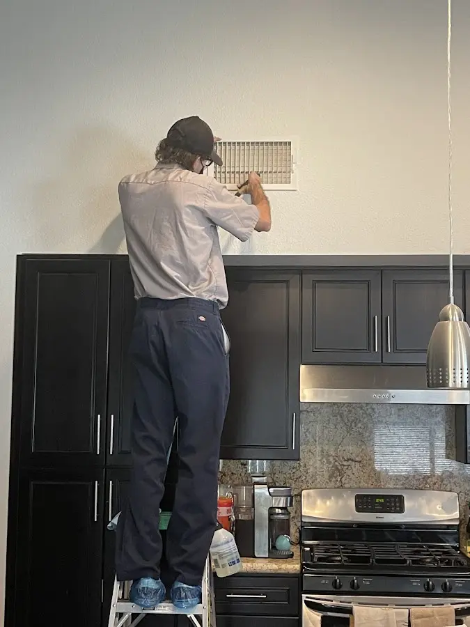 Technician inspecting an air vent during HVAC service in West Rancho Dominguez
